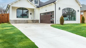 Een gelijkvloers huis met garage, overdekt terras en een verzorgd gazon.
