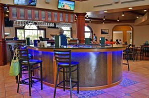 Socialize and dine at the central bar, surrounded by comfortable seating and a large television for entertainment.