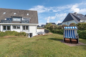 Una zona residenziale con case, un prato e una sedia da spiaggia.