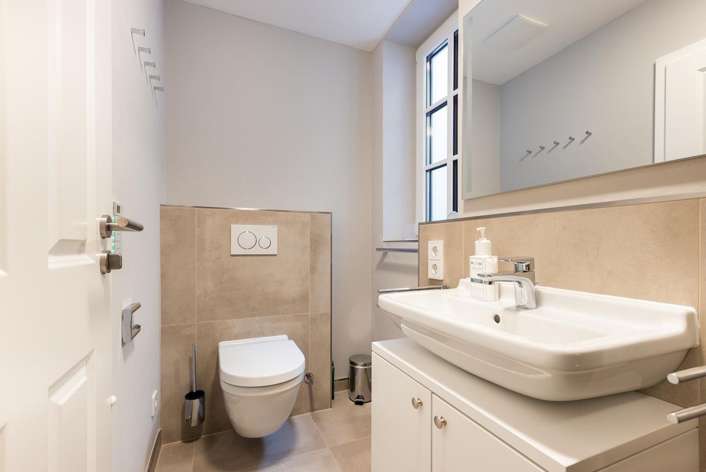 Une salle de bain moderne avec des toilettes, un lavabo et un miroir.