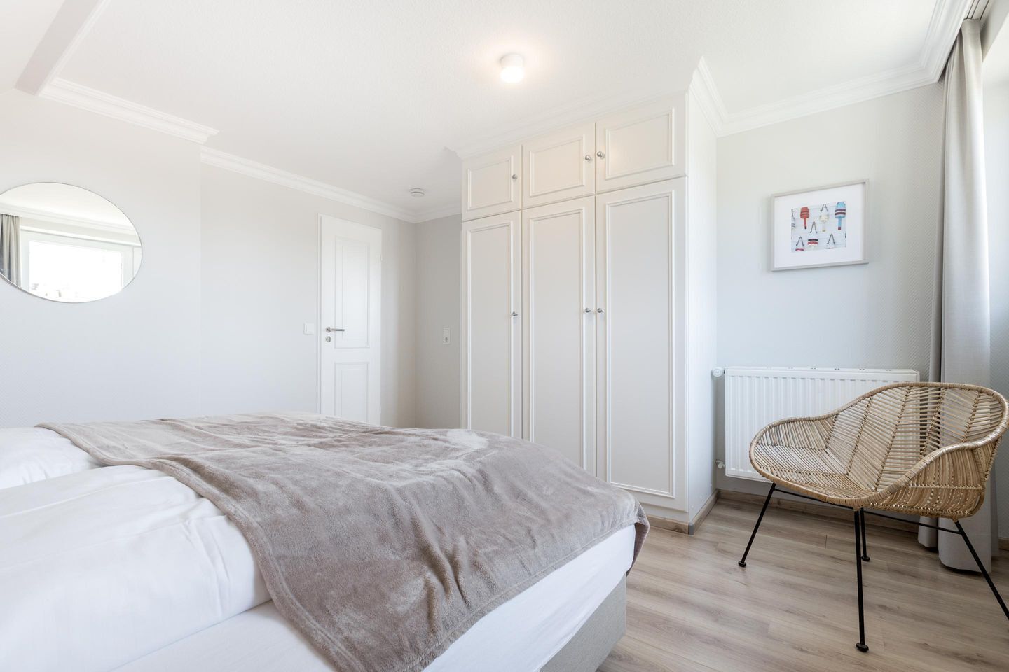 A bedroom with a bed, a wardrobe, a chair, and a radiator.