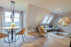 Um apartamento loft moderno com área de refeições, sofá, espelho redondo e claraboia.