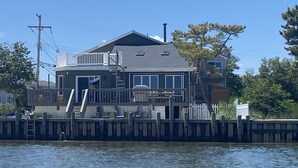 A two-story house with a dock extending into a body of water.