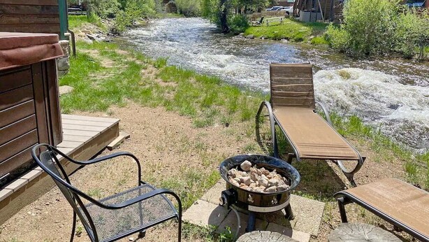 A riverside patio with outdoor seating and a fire pit. - On The River, Hot Tub, Walk to Town #6002 (Estes Park)