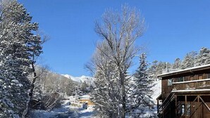 A snow-covered river with a wooden building on the right. - On The River, Hot Tub, Walk to Town #6002 (Estes Park)