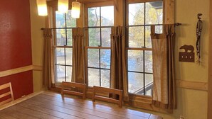 A room with large windows, wooden benches, and a chandelier. - On The River, Hot Tub, Walk to Town #6002 (Estes Park)