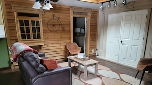A cozy living room with a leather sofa, a wooden coffee table, and a patterned rug. - Country Guest House  (Plymouth)