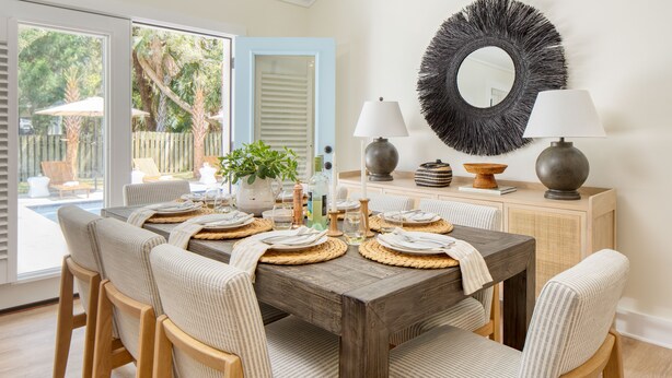 A dining area with a wooden table set for six, surrounded by cushioned chairs. - Sawyer by AvantStay | Stunning Isle Of Palms Home w/ Pool! (Isle Of Palms)