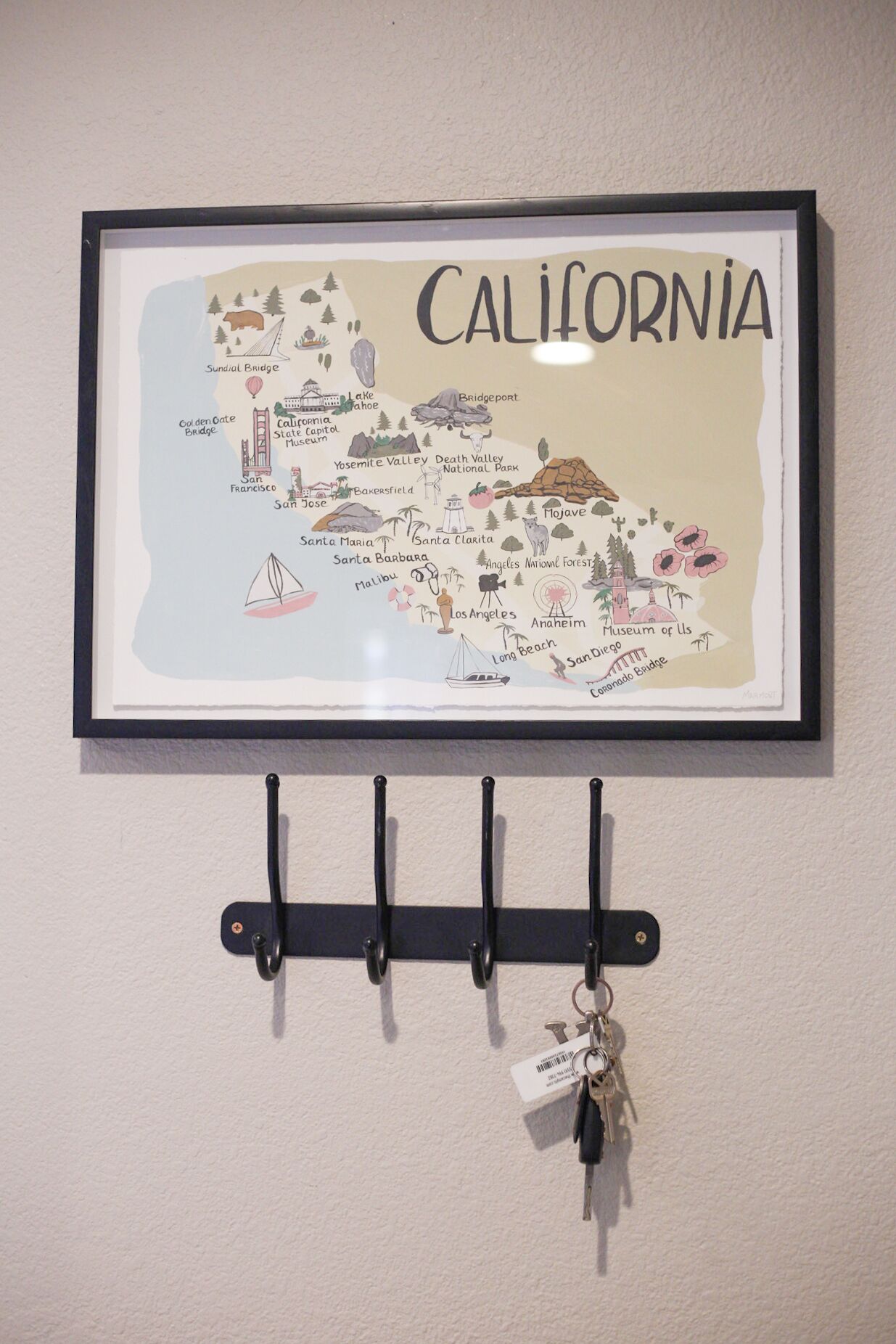 A framed map of California with a key hanging below it.