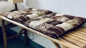 A wooden bench with a patterned cushion against a white wall. - Mediterranean apartment centrally located 500m beach (Sant Feliu de Guíxols)