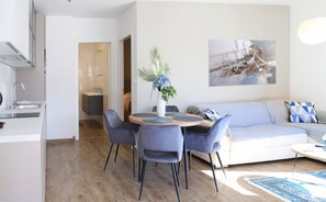 Una sala de estar moderna con comedor, cocina y baño.