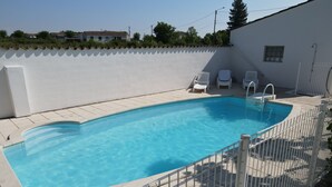 A swimming pool with a white fence, a small window, and a tiled deck. - Gîte Caramolle, St Denis, Gard, Cévennes, 2 bedrooms, swimming pool, nature (Saint-Denis)