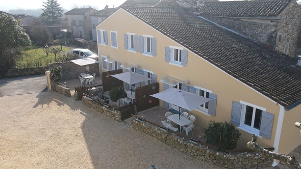 A two-story house with a patio area featuring outdoor furniture and umbrellas. - Gîte Caramolle, St Denis, Gard, Cévennes, 2 bedrooms, swimming pool, nature (Saint-Denis)