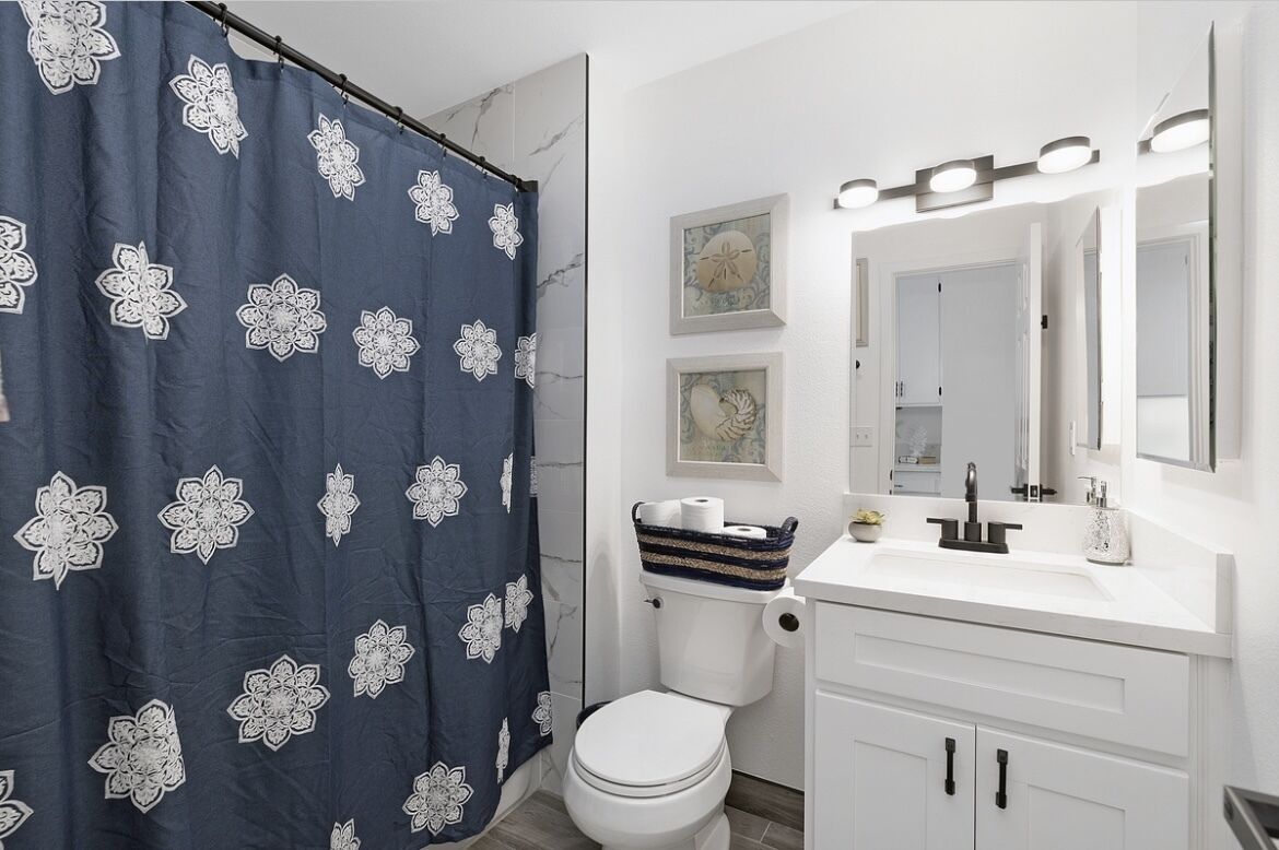Een badkamer met een witte wastafel, een spiegel en een toilet.