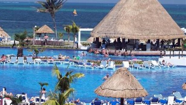 A resort pool area with thatched-roof structures, lounge chairs, and a view of the ocean. - **ATLANTIS BAHAMAS, PARADISE** - BEAUTIFUL 1 BEDROOM, SLEEPS 4+  (Paradise Island)