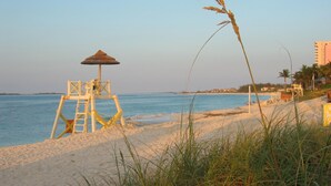 A beach with a lifeguard tower and a beach umbrella. - **ATLANTIS BAHAMAS, PARADISE** - BEAUTIFUL 1 BEDROOM, SLEEPS 4+  (Paradise Island)
