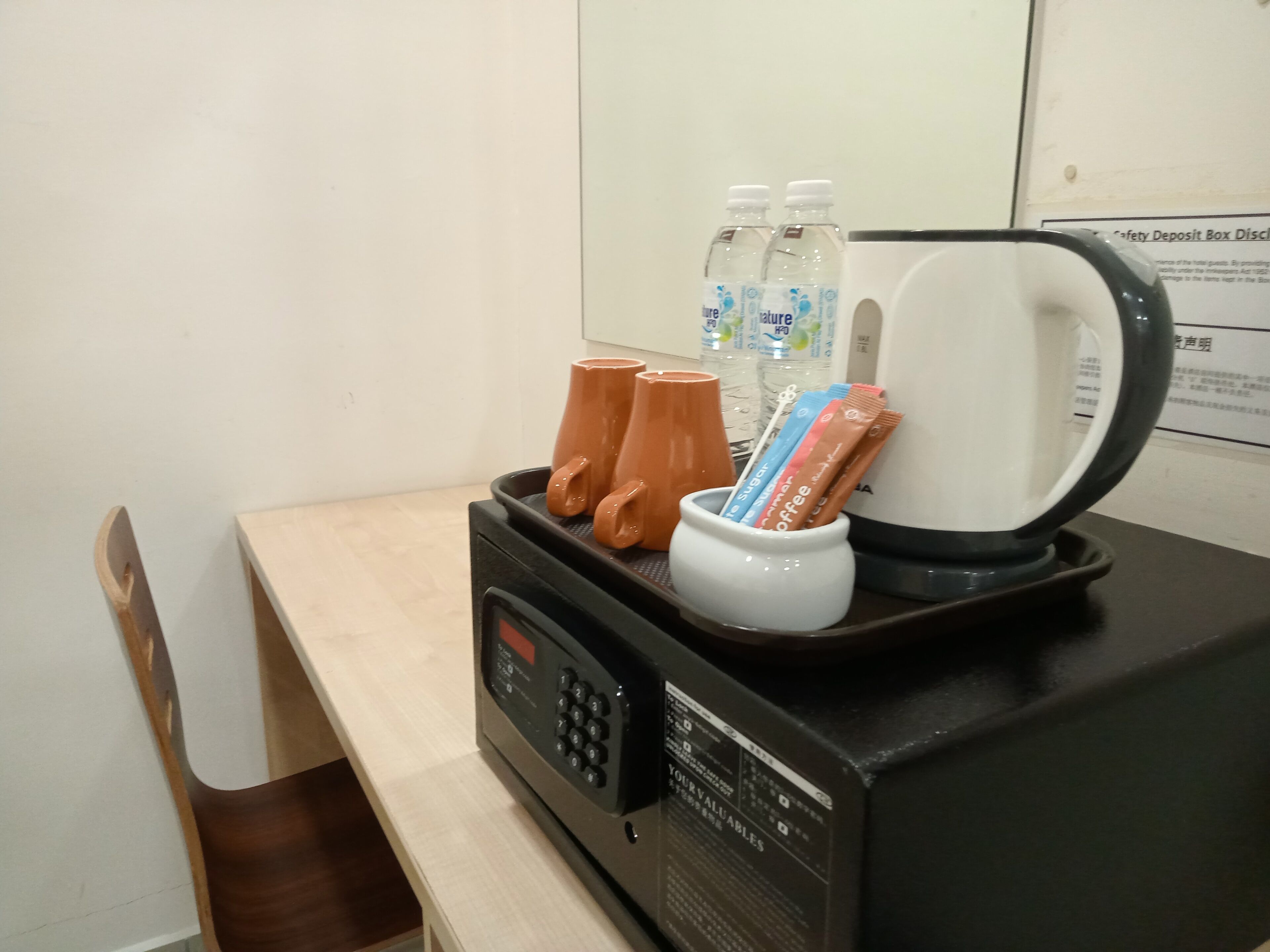 Un microondas con cafetera y dispensador de agua sobre una mesa.