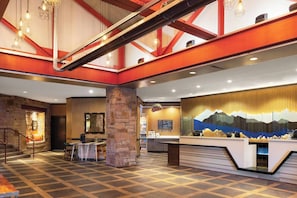 Experience the grandeur of our lobby, featuring a high ceiling, patterned tile floor, and a striking mural.