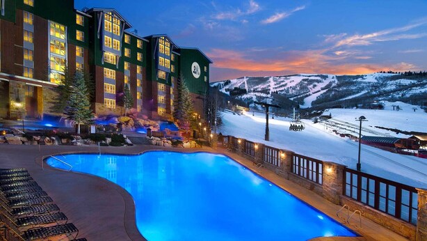 A hotel with a swimming pool, outdoor seating, and a view of a snowy mountain. - Marriott MountainSide - Ski-In & Ski-Out - Enjoy Full Resort Access - Sleeps 8 (Park City)