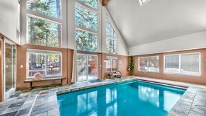 Una amplia piscina interior con techos altos y ventanas grandes.