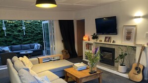 Ein modernes Wohnzimmer mit Sofa, Couchtisch und Kamin.