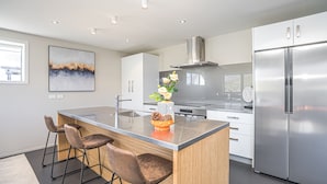 A modern kitchen with a central island, stainless steel appliances, and a decorative vase.