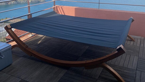 A hammock on a wooden deck with a view of the ocean and distant land. - Exceptional sea view apartment (Cerbère)