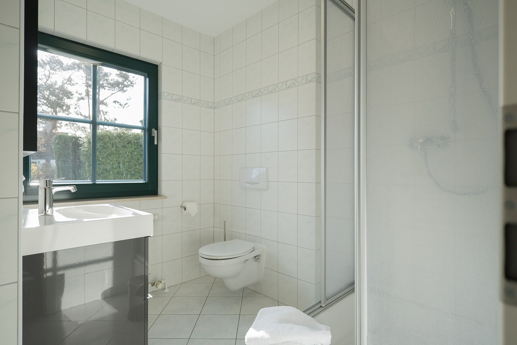 Une salle de bain avec des toilettes, un lavabo et une douche.