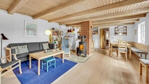 Una sala de estar acogedora con chimenea, muebles de madera y una estantería.