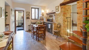 A cozy kitchen with a stone wall, wooden furniture, and a dining area with a table and chairs. - Nice apartment in Civitella del Lago with WiFi (Civitella del Lago)