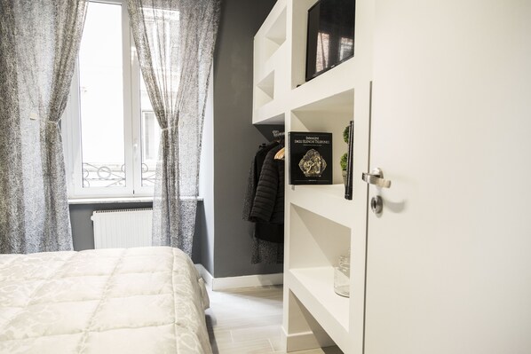 A bedroom with a bed, a wardrobe, and a window with curtains.