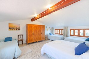 Quarto com duas camas, um guarda-roupa e um quadro na parede.