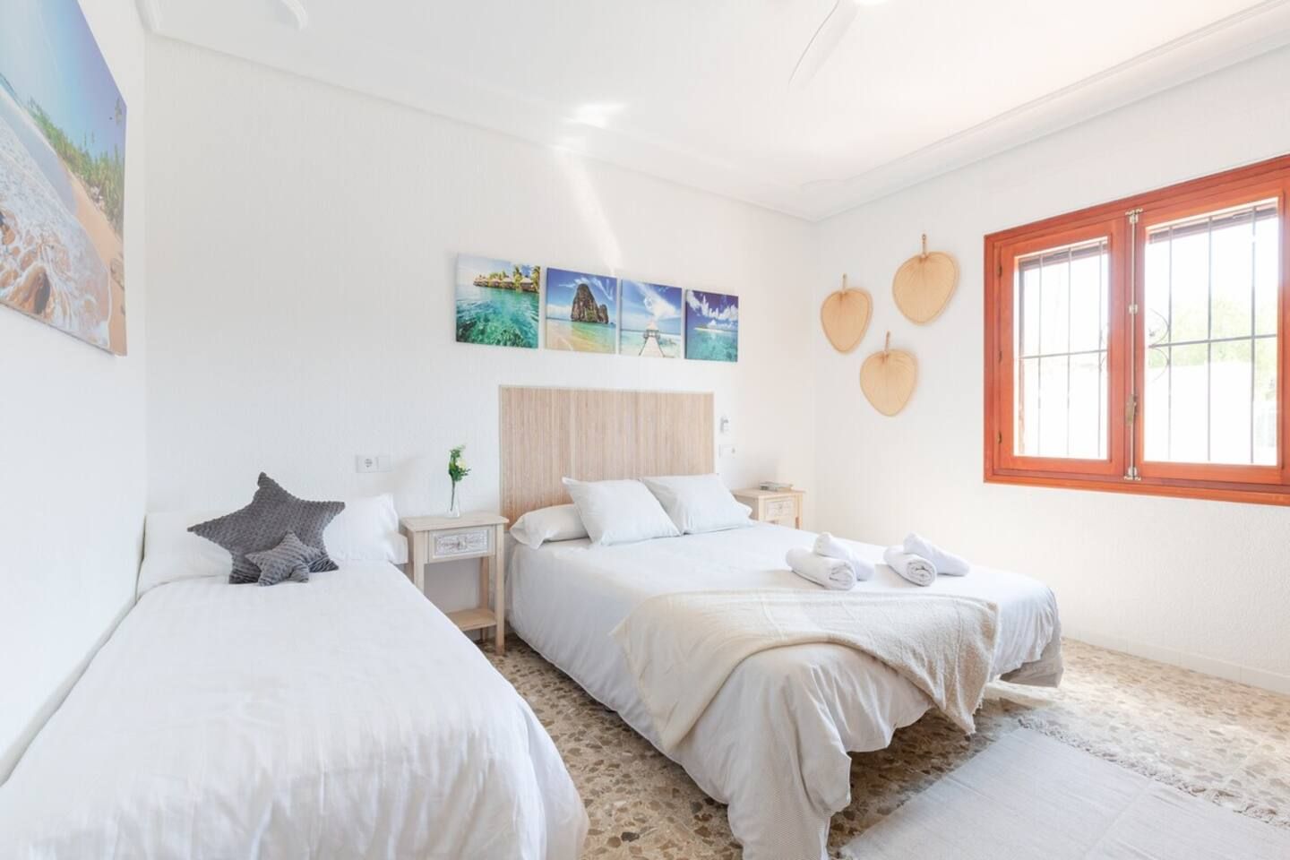 Une chambre d’hôtel avec deux lits, une grande fenêtre et des œuvres d’art murales.