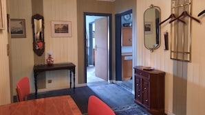 A dining area with a wooden table and chairs, a console table with a vase, and a mirror on the wall. - Living in a stately home from 1848 in the Fichtelgebirge (Ebnath)