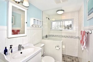 Tina con regadera, secadora de cabello, toallas, papel de baño