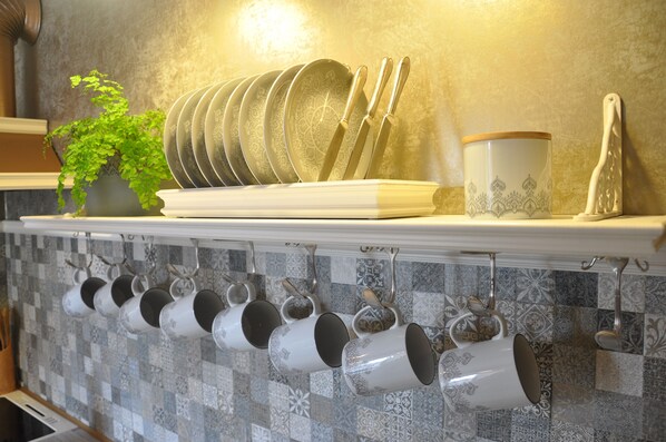 A kitchen with a white shelf holding plates, cups, and utensils. - Cozy country-style vacation apartment on the slopes of the Elbe (Pirna)