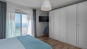 A bedroom with a bed, a TV, a chair, and a wardrobe. - Nice home in Bregi with sauna (Bregi)