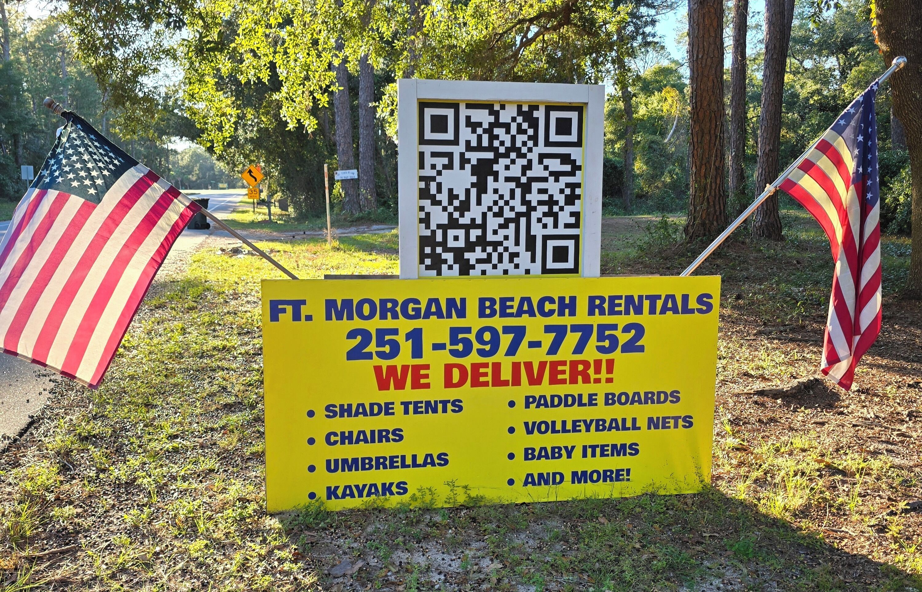 Une pancarte indiquant les locations de Morgan Beach Rentals, avec un code QR, et affichant une liste d’articles disponibles à la location, tels que des parasols, des kayaks et des planches de paddle.