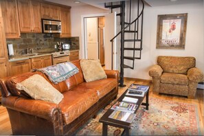 Relax in this inviting living space with a cozy sofa, patterned rug, and warm decor.
