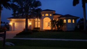 A residential house with a garage, a well-maintained lawn, and palm trees. - Marco Island Waterfront Home w/Heated Pool, Bikes, < 2 Miles to the Beach (Marco Island)