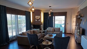 Uma sala de estar moderna com sofá, poltronas, mesa de centro e lareira.