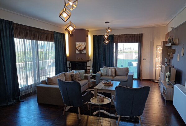A modern living room with a sofa, chairs, a coffee table, and a fireplace.