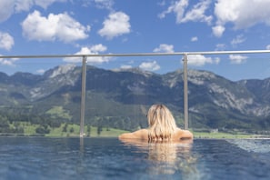 A person in a pool with a mountain landscape in the background.