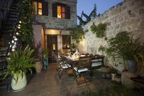 Relax in the serene outdoor patio area, surrounded by lush greenery and comfortable seating.