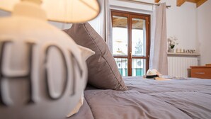 Un lit avec une couette grise et un oreiller sur lequel est brodé le mot « MAISON ».