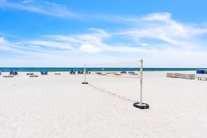 A beach volleyball court with net, chairs, and benches. - Sand Dollar 107 Gorgeous Beachfront Views, Spacious, Pool, BBQ, Private Pier (Indian Shores)