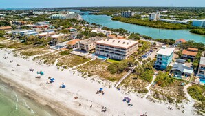 An aerial view of a coastal area with a beach, buildings, and a river. - Oceanside302 Beachfront- Gorgeous Gulf Views, lots of updates, great location (Indian Rocks Beach)