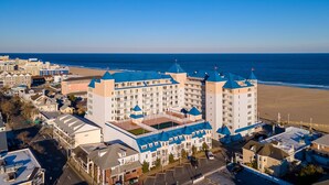 Un hotel con múltiples torres, vista al mar y zona de estacionamiento.