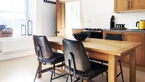 A modern kitchen with wooden cabinets, a black countertop, and a yellow kettle. - Short breaks available!! (St Davids)