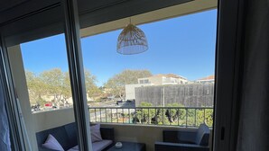 Un balcon donnant sur un quartier résidentiel, avec vue sur des maisons et des arbres.
